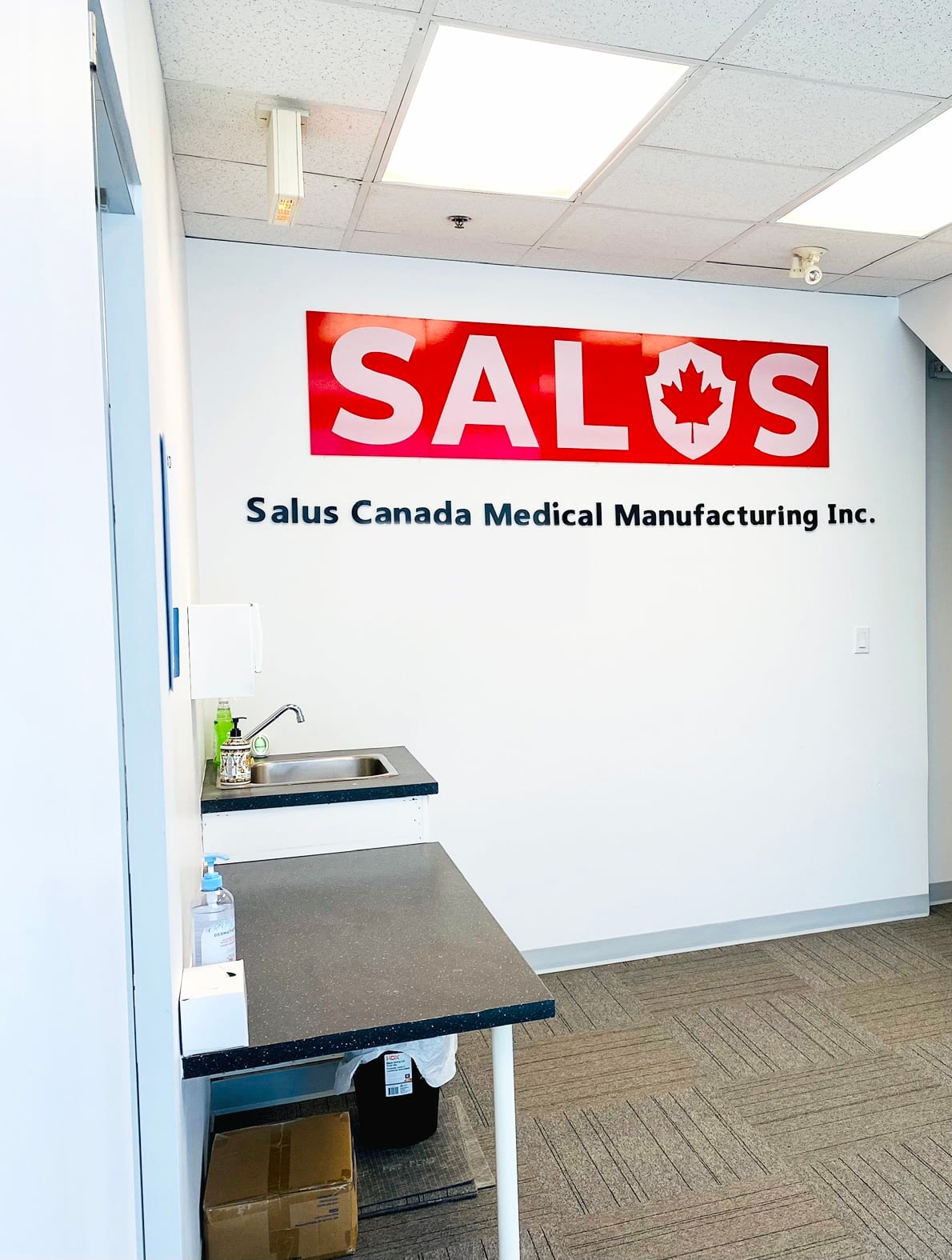 Facility entry at Salus Canada: gowning station and SALUS sign
